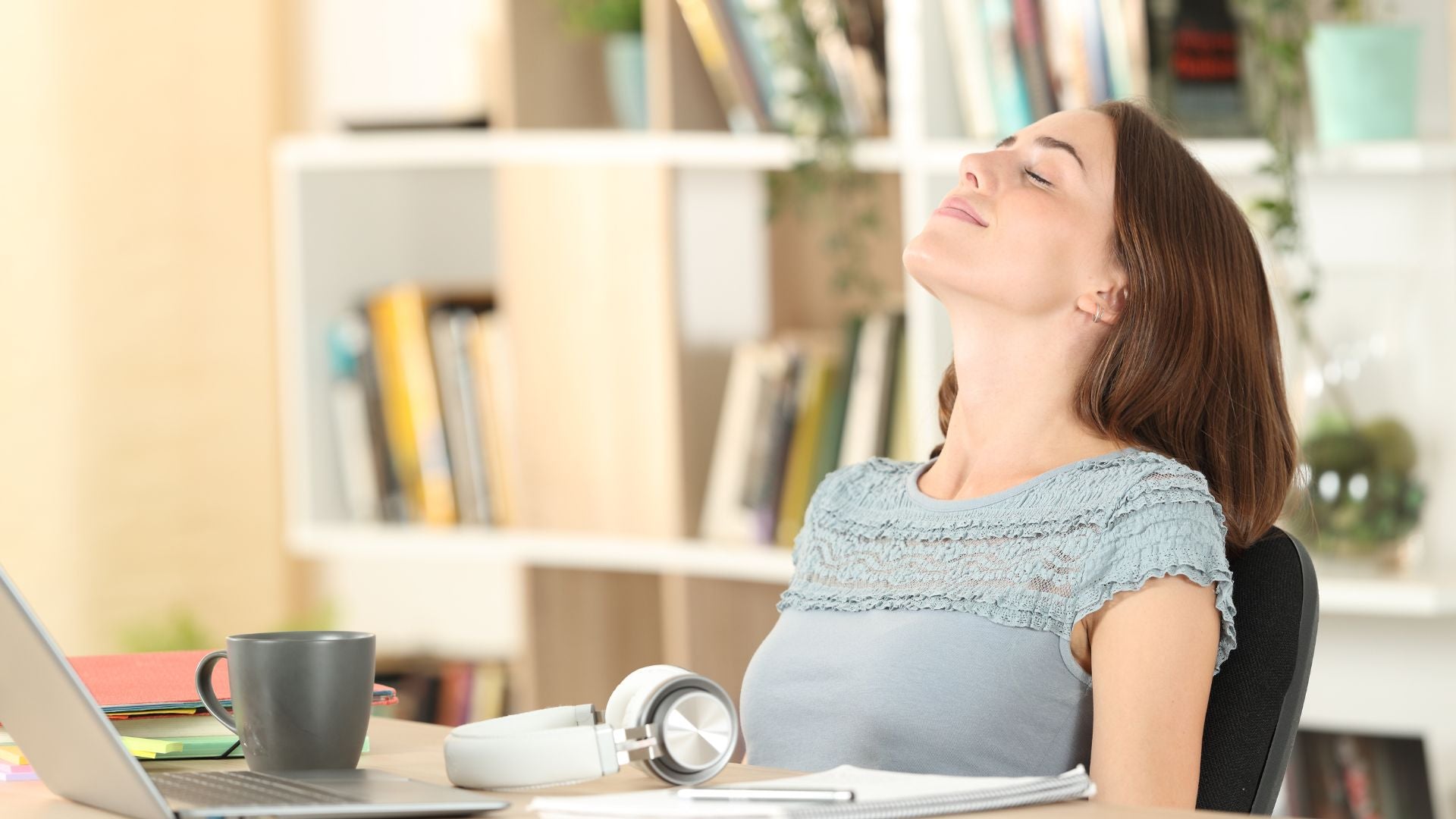 Woman enjoying breath of fresh air in front of her computer