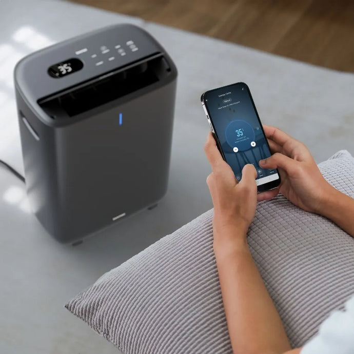 Person using the Ionmax app to control the Ionmax Venta ION615 Desiccant Dehumidifier