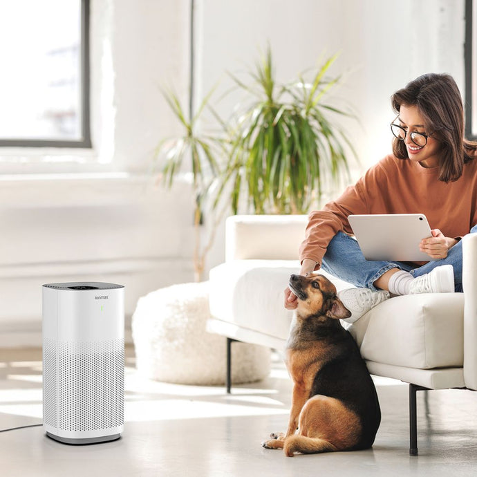 A woman and her pet dog with the Ionmax Lavish Plus air purifier